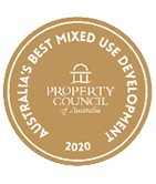 A gold circular badge with white text reading Australia's Best Mixed Use Development 2020 and the Property Council of Australia logo in the center. Description generated by AI