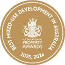 Gold circular emblem with a crest in the center and text indicating an award for the best mixed-use development in Australia for the years 2025 and 2026. Description generated by AI