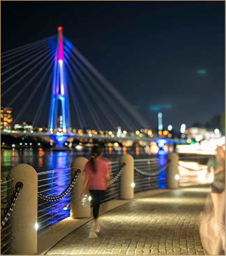 A large bridge spans over a body of water, with a city in the background. AI generated content