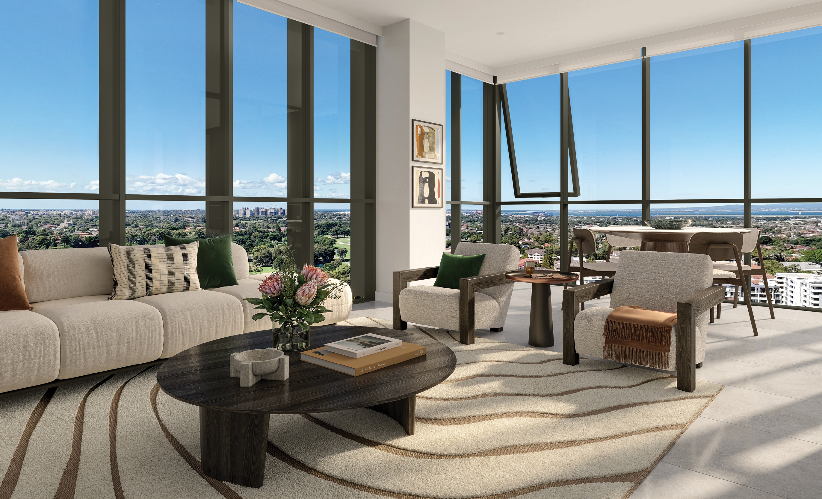 A modern living room with large floor-to-ceiling windows overlooking a cityscape features a beige sofa, two armchairs, a round wooden coffee table with flowers and books, and a dining area in the background. Description generated by AI