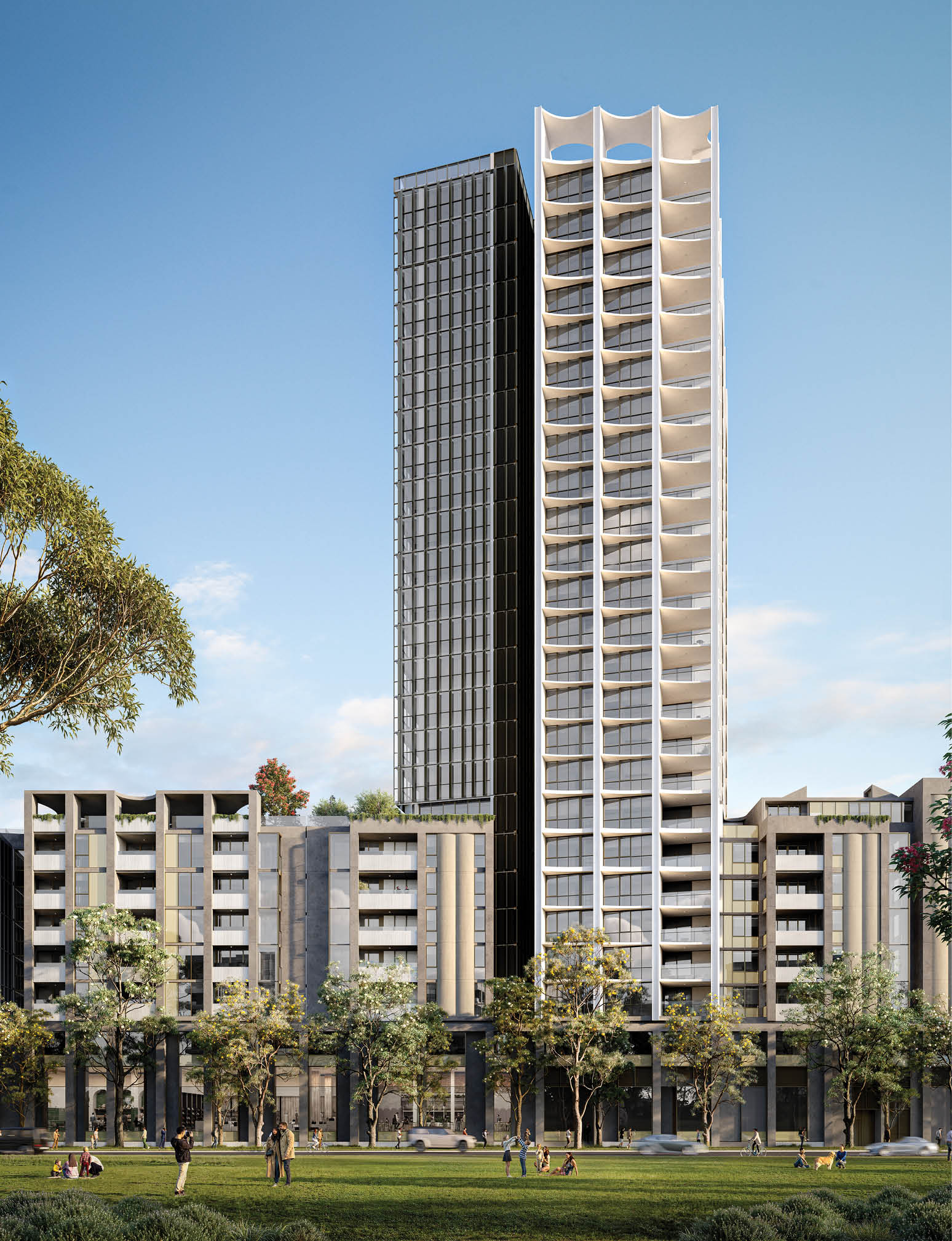 A modern urban scene with a tall, uniquely designed white and black high-rise building surrounded by shorter residential buildings and trees, with people walking and sitting on the grass in the foreground under a clear blue sky. Description generated by AI
