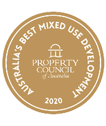 A gold circular badge with white text reading Australia's Best Mixed Use Development 2020 and the Property Council of Australia logo in the center. Description generated by AI